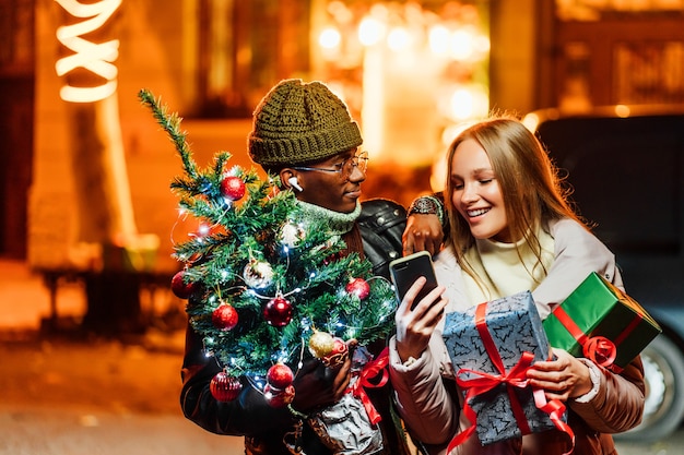 Premium Photo Joyful African American Man With Caucasian Woman Outdoors Doing Christmas Gifts Online