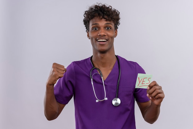 Free Photo A Joyful Young Handsome Dark Skinned Male Doctor With Curly Hair Wearing Violet 1853