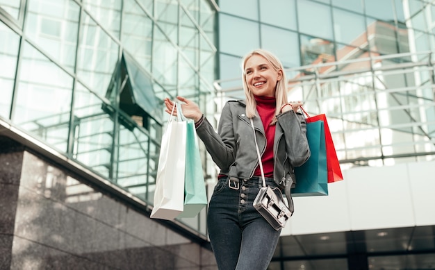 Premium Photo | Joyful young stylish female shopper carrying colorful ...