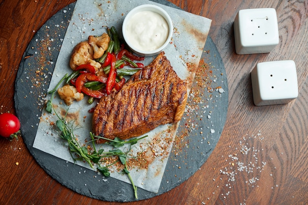 Premium Photo Juicy And Mouth Watering Grilled Ribeye Steak With Spicy Butter On A Black Tray