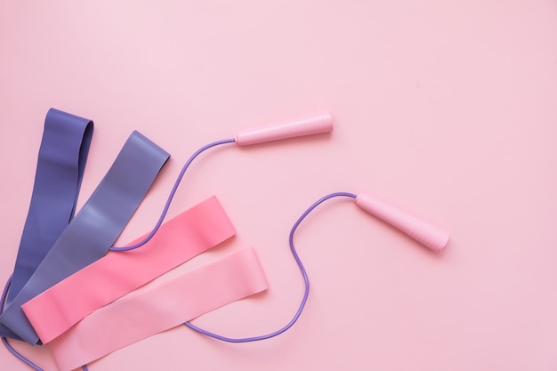 Jump or skipping rope and fitness elastic band on pink background. fitness trend. Premium Photo