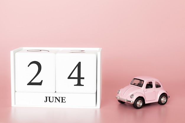 June 24th, day 24 of month, calendar cube on modern pink background with car Premium Photo