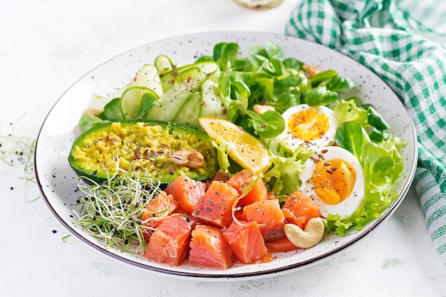 Ketogenic diet breakfast. salt salmon salad with greens, cucumbers, eggs and avocado. keto/paleo lunch. Free Photo