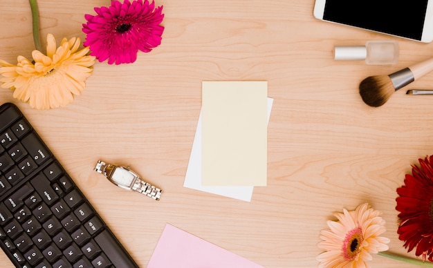 Keyboard; gerbera flower; wrist watch; blank paper; nail varnish; makeup brush and cellphone on wooden desk Photo - Free Download - 웹