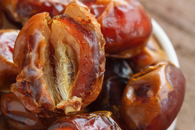 Premium Photo | Khalas dates palm fruit on wood table in close up view ...