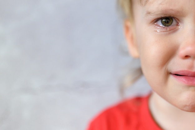 プレミアム写真 泣いている子供 涙でかわいい動揺して4歳の男の子の顔 子供の悲しみ 灰色のコンクリートの壁の背景 テキストのためのスペース