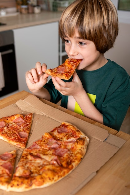 Free Photo | Kid eating pizza at home