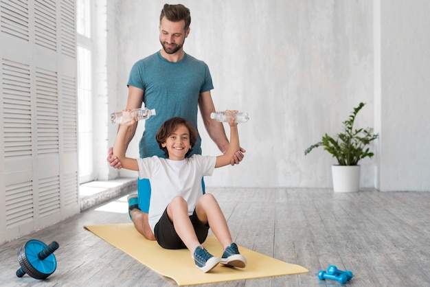 Kid and his father doing sport at home Premium Photo