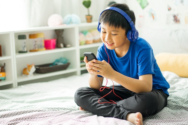 Premium Photo | Kid listening to music on bed at bedroom for relax