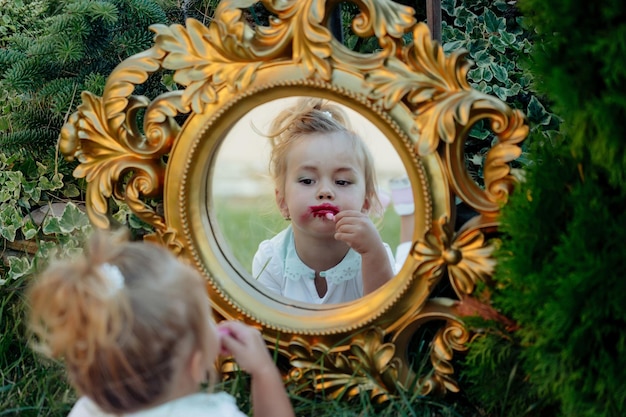 Premium Photo | Kid model put red lipstick on lips