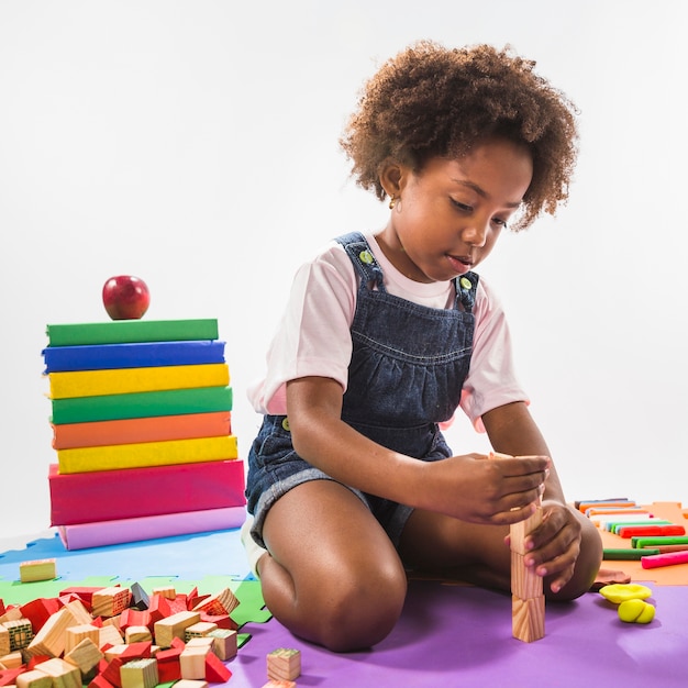 Kid playing with cubes on play mat in studio | Free Photo