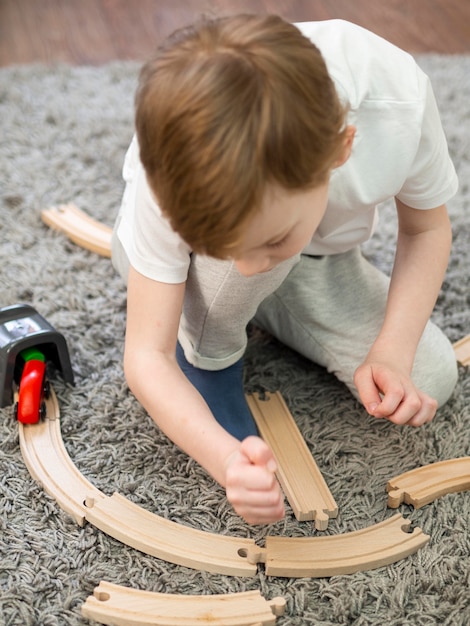 木製の道路で遊んでいる子供と床で車のゲーム 無料の写真