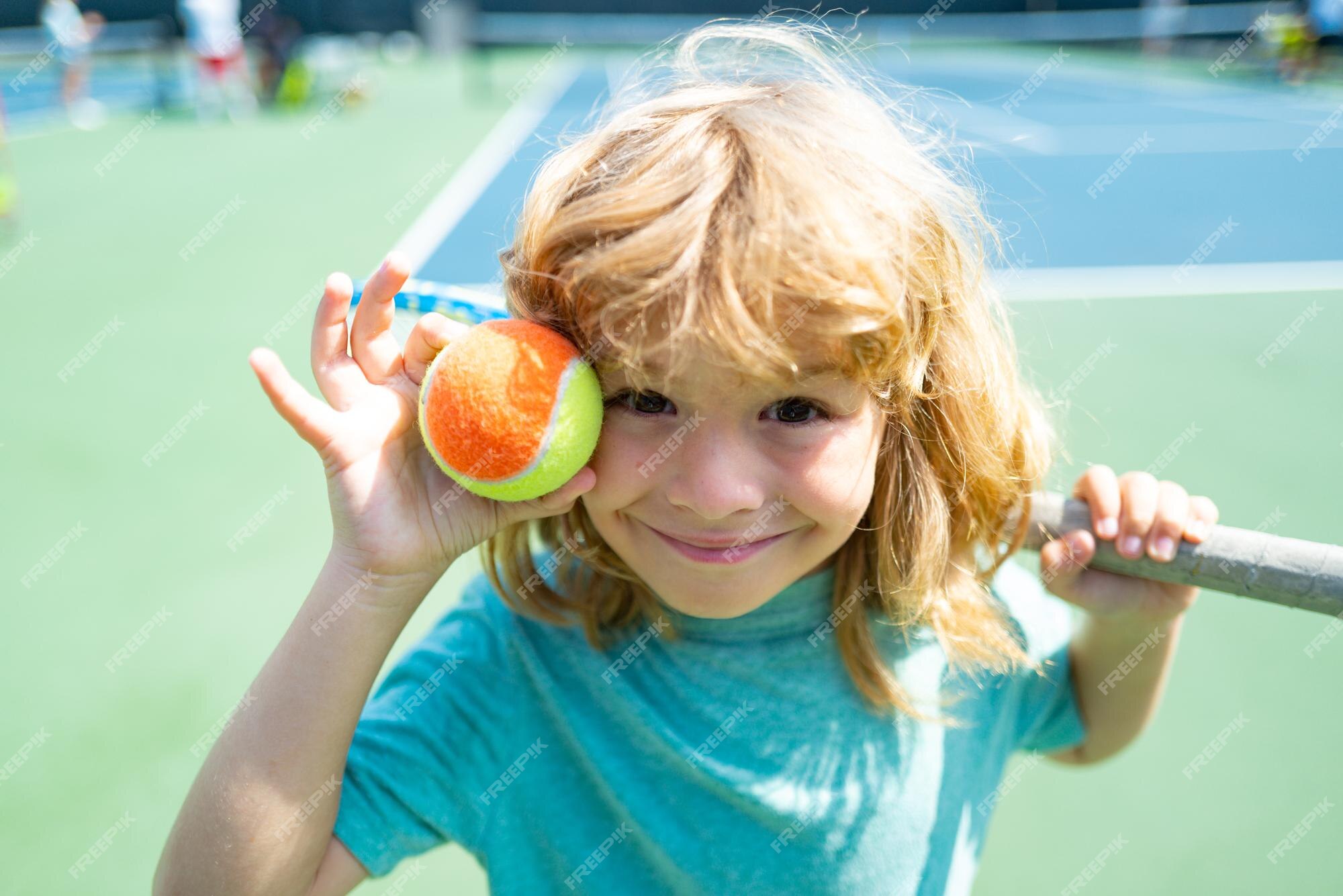 premium-photo-kid-tennis-player-on-tennis-court-with-racket-and-balls