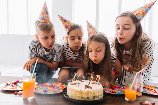 Kids blowing out birthday candles together Photo | Free Download