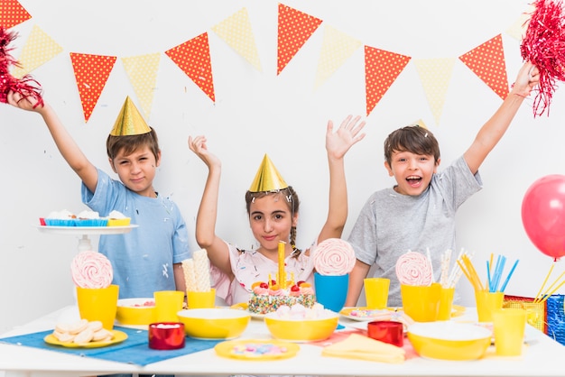 テーブルの上に食べ物の様々な家で誕生日パーティーを祝う子供たち 無料の写真