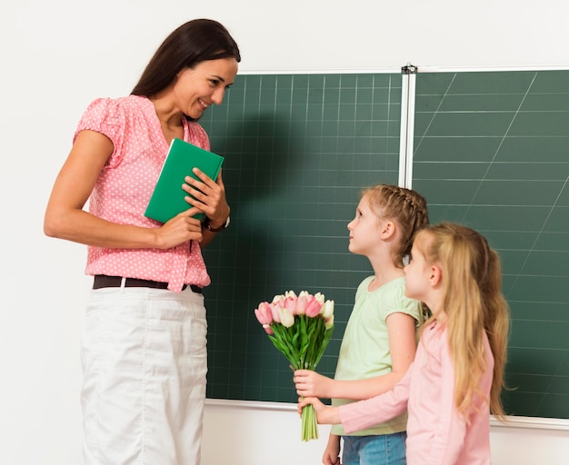 Free Photo Kids giving flowers to their teacher