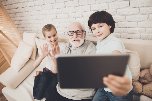Kids And Grandfather Make Video Call With Tablet Photo