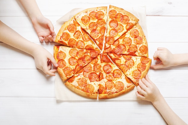 Premium Photo | Kids holding a slice of pizza.