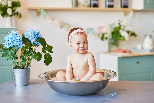 子供の衛生 子供用のシャンプー ヘアトリートメント 石鹸 大きな浴槽での子供の入浴 女の赤ちゃんの洗浄 乳児の衛生 健康とスキンケア お風呂で赤ちゃん プレミアム写真