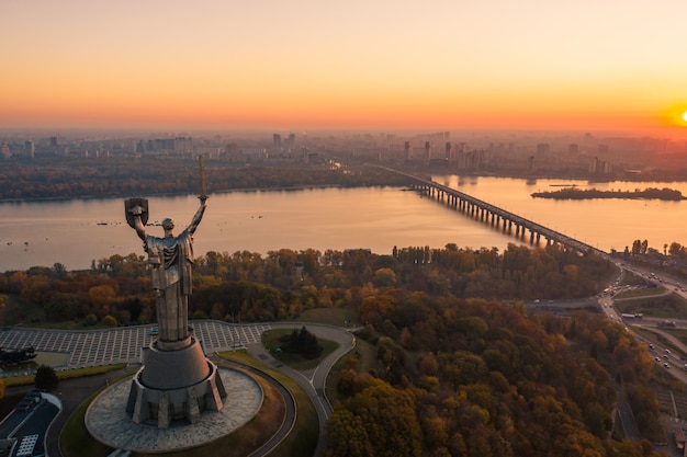 Kiev skyline over beautiful fiery sunset, ukraine. monument motherland. Free Photo