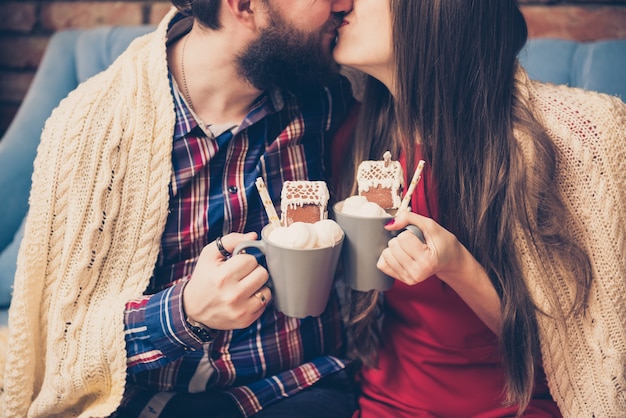 カップルのキス ホットコーヒーのマグカップとマシュマロの男女 トリミングされた画像 プレミアム写真