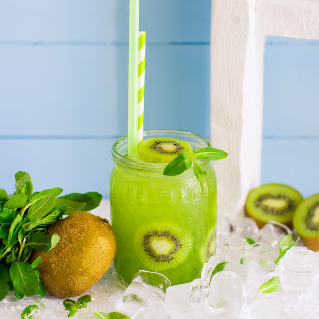 Free Photo | Kiwi cocktail served with kiwi pieces and ice in glass jar