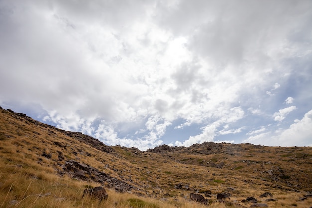 スペイン シエラネバダ山脈の曇り空の下の乾燥した丘の中腹の風景 無料の写真