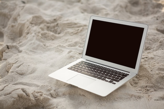 Laptop kept on sand Free Photo