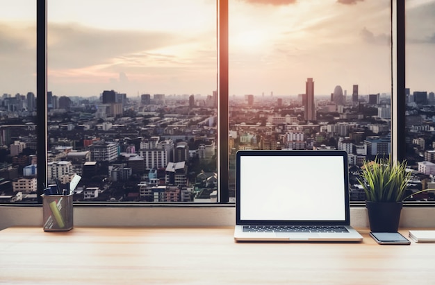 Premium Photo | Laptop on table in office room on window city background