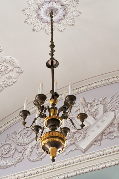 A Large Chandelier With Candles Hangs, Who Hangs Chandeliers