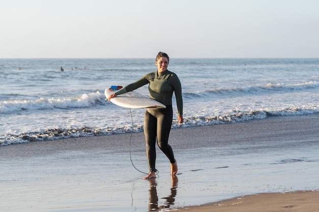 Premium Photo | Latin female surfer with surfboard walking and smiling ...