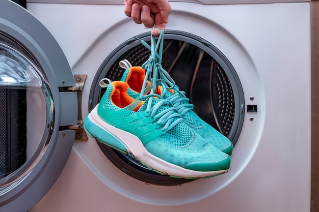 Laundry dirty sports shoes in a washing machine | Premium Photo