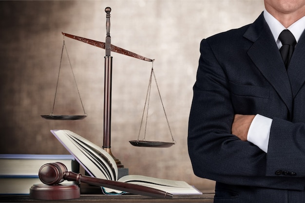 Premium Photo | Lawyer standing with crossed arms, scales of justice on ...