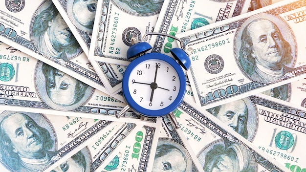 A layer of money with clock in the center. finance idea Free Photo