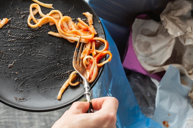 Leftover wasted spaghetti pasta thrown in a bin Free Photo