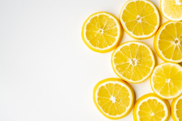 Lemon slices randomly lie on one side on a light table surface. flat lay, close-up. Premium Photo