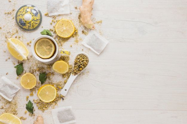 Lemon tea with dried chinese chrysanthemum flowers and lemon slices on wooden table Free Photo
