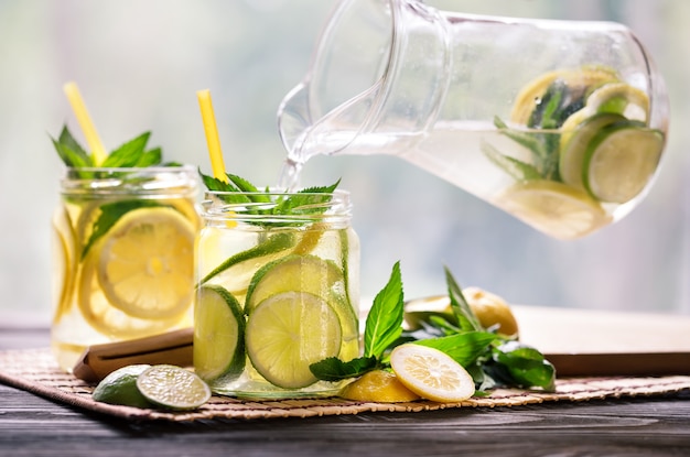 Premium Photo | Lemonade with lemon and lime in glass jars shot with ...