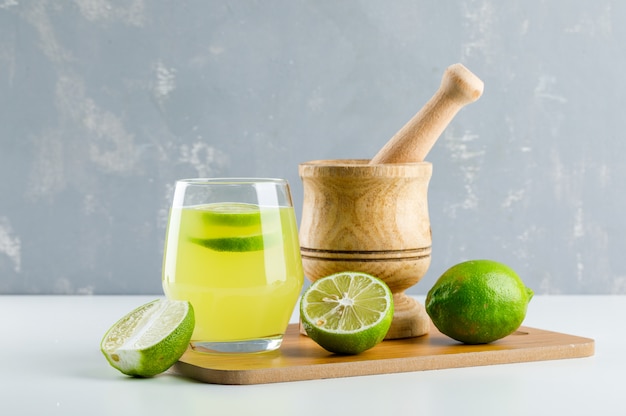 Free Photo | Lemonade with lemon, mortar and pestle, cutting board in a ...