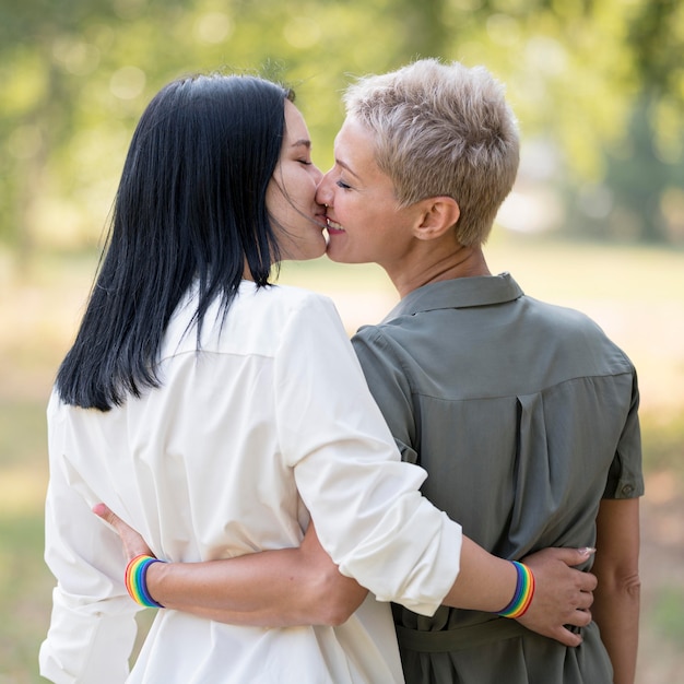 Back View Of Lesbian Couple Holding Hands While Standing In Forest Stockpho...