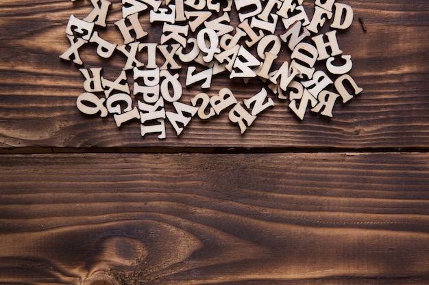 暗い木製の背景に英語のアルファベットの文字 教育 ワードゲーム 裁縫の概念 テキスト用のスペース プレミアム写真
