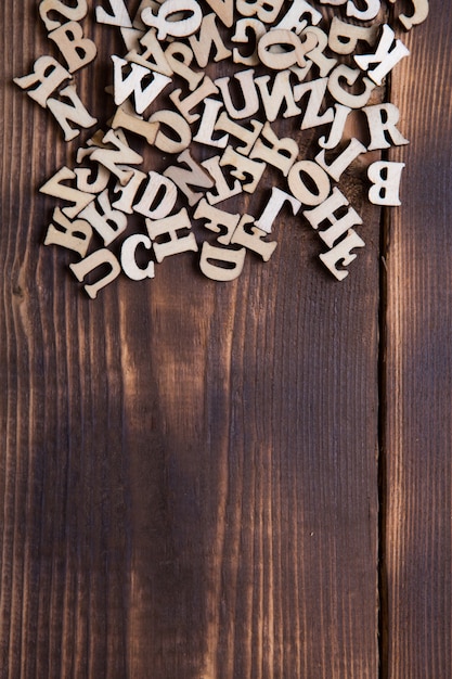 暗い木製の背景に英語のアルファベットの文字 教育 ワードゲーム 裁縫の概念 テキスト用のスペース プレミアム写真