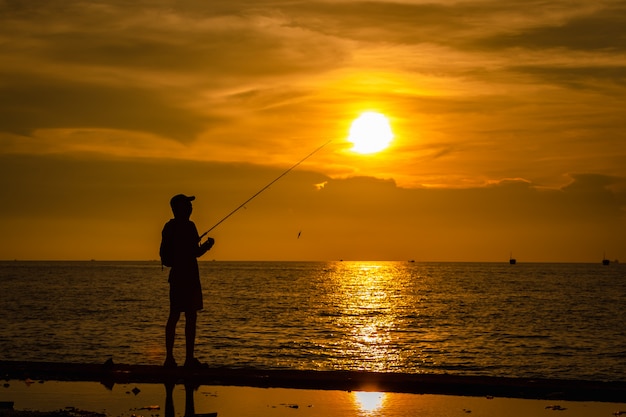 Life Portrait Fishermen Silhouette On The Sea And The Sunset Over