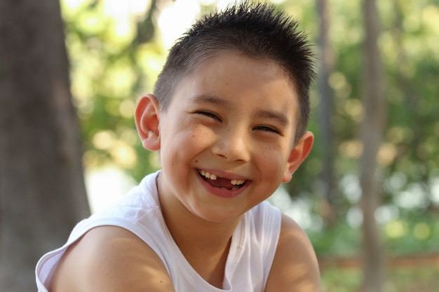 プレミアム写真 ライフスタイルカメラに笑顔かわいい歯のない日本人男の子