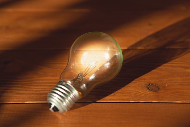 Premium Photo | Light bulb on a wooden background. concept ideas