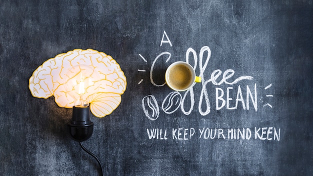 Lighted brain light bulb with text on chalkboard Free Photo