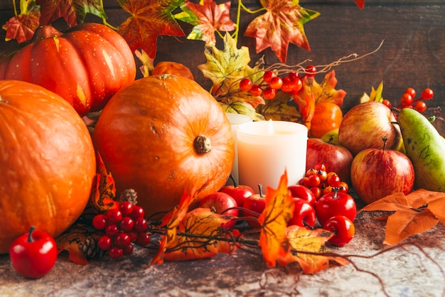 Lighted candles among autumnal harvest Photo | Free Download