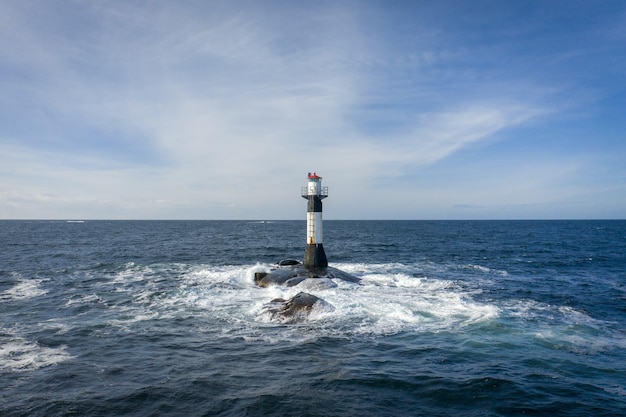 Free Photo | Lighthouse in the middle of the sea under the cloudy sky