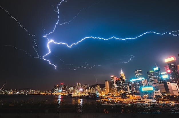 Lightning strike over a modern urban city at night Free Photo