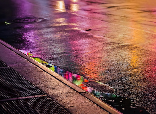ニューヨーク市の光と影 雨の後の濡れたアスファルトでの反射とニューヨークの通り 通りを歩く人のシルエット プレミアム写真